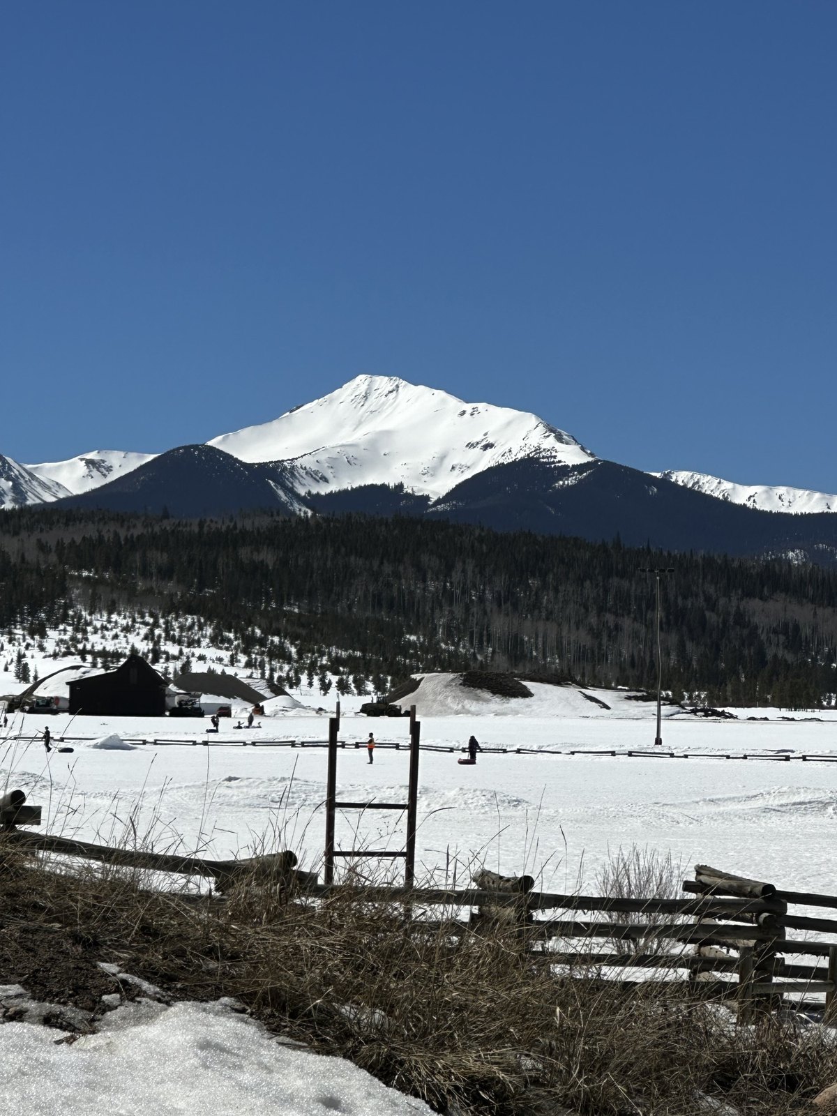 Snow play in Fraser with a snow-capped peak behind the valley