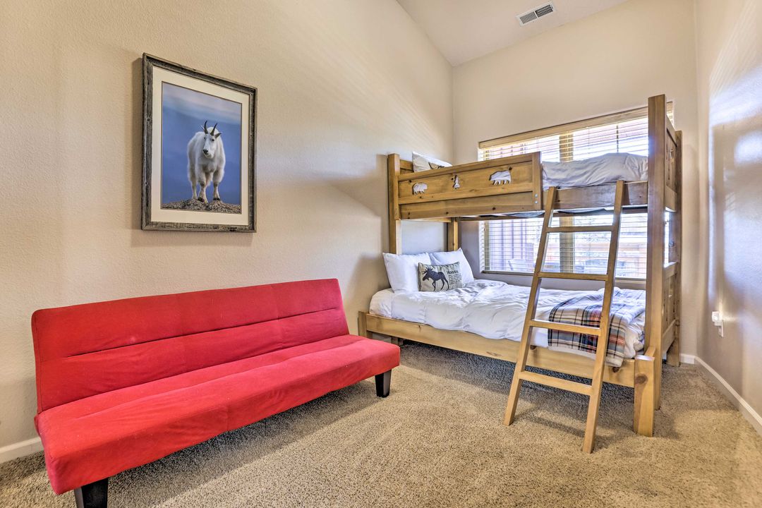 Bunk bedroom with wooden bunks and a red futon in the Fraser condo