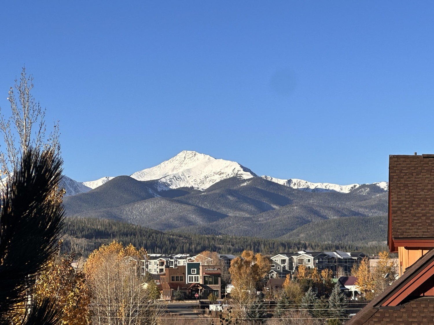 Snow-capped peak above Fraser, Colorado townhomes in fall