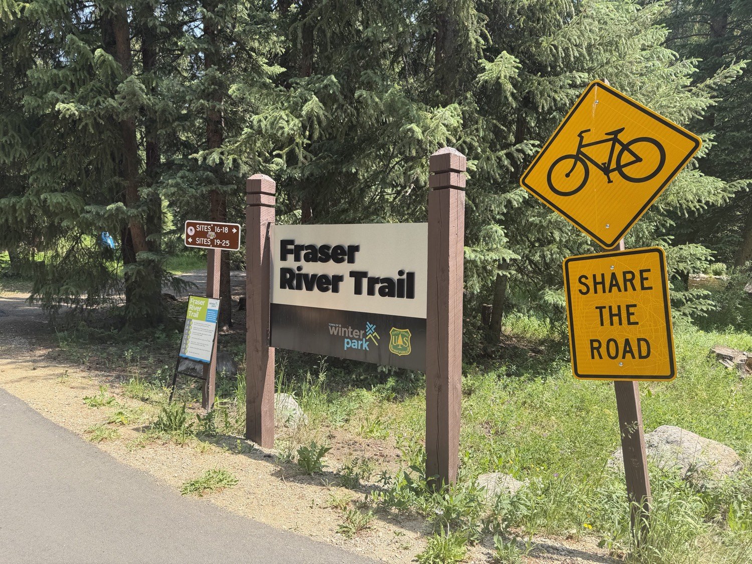 Fraser River Trail sign with a Share the Road bicycle sign in Fraser, Colorado