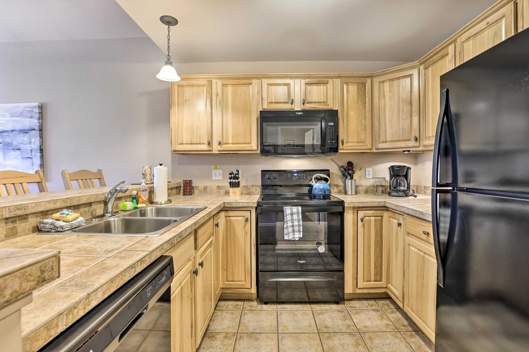 Full kitchen with black appliances and light wood cabinets in the Fraser vacation rental